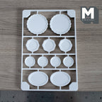 1:12 scale miniature dinner plate and platter kit, set of 11, white round and oval plates on a sprue, above a ruler