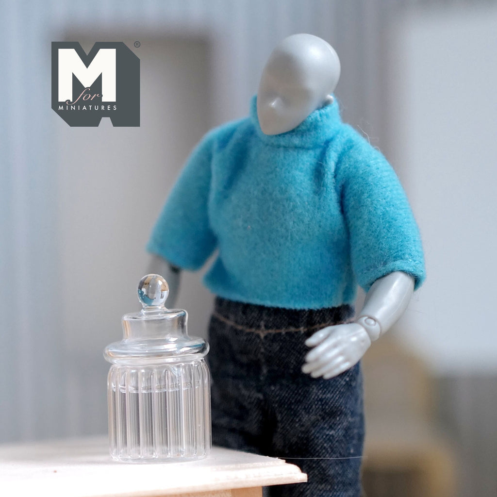 1:12 scale miniature ribbed glass canister with lid in clear, round knob top, shown beside a poseable figure