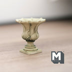 1:12 scale miniature cast resin Roman style garden urn with pedestal in antique cream, leaf relief, on a wood floor