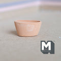 1:12 scale miniature clay oval flower pot in beige, unglazed with a leaf imprint on the side, shown empty