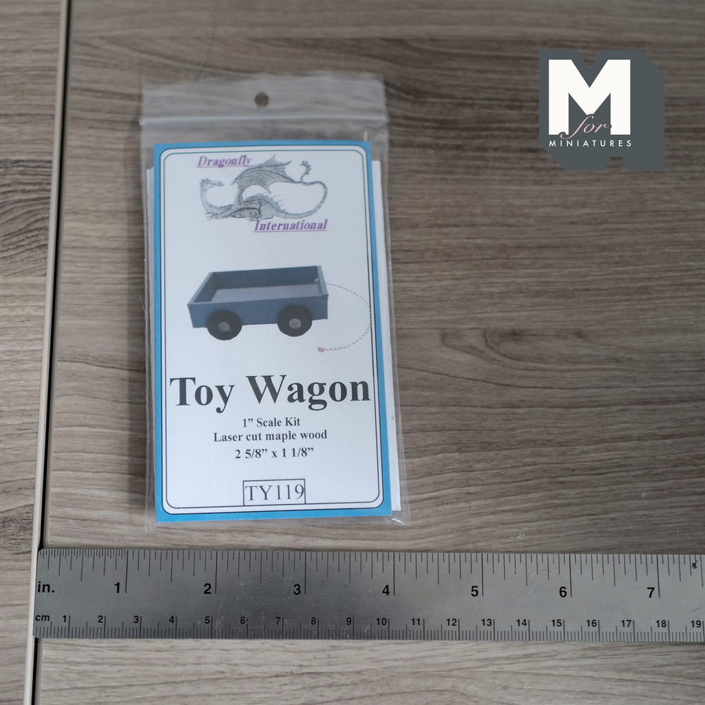 1:12 scale miniature maple wood toy wagon kit, shown in its package beside a ruler for scale