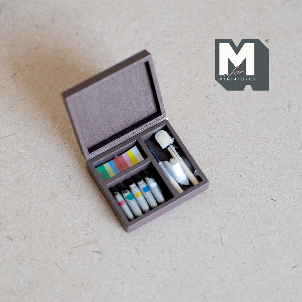 1:12 scale miniature paint set in wooden box with paint tubes and brushes, lid open, shown on a linen surface