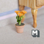 1:12 scale miniature potted chrysanthemum with orange blooms and green leaves in a terracotta pot, shown on the floor
