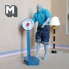1:12 scale miniature blue standing weighing scale with round dial, non working, shown with a poseable figure