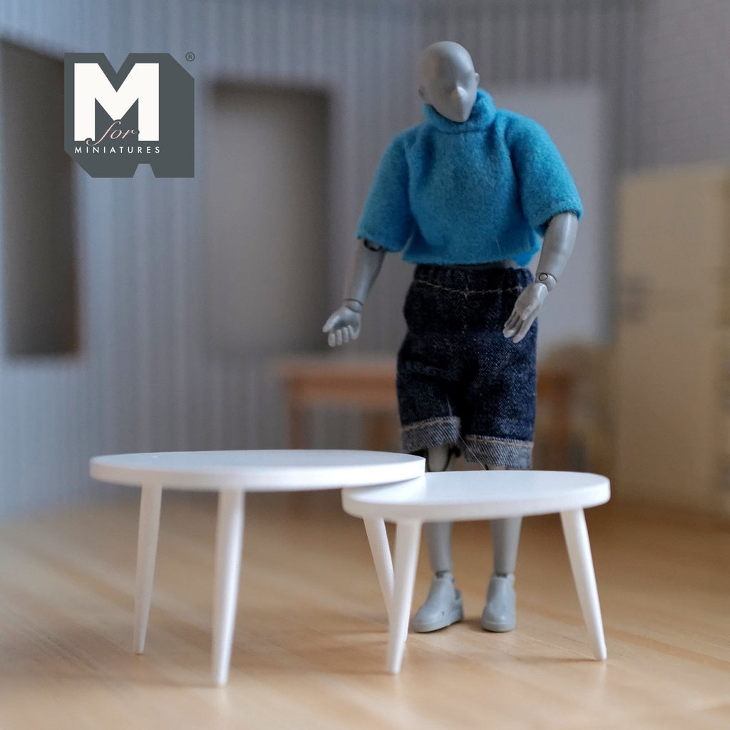 1:12 scale miniature wood oval nesting coffee tables in white with splayed legs, set of 2, shown with a poseable figure