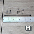 1:12 scale miniature metal curtain rod in dark gray with rings and brackets, shown laid out with a ruler for scale