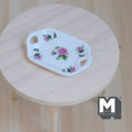 1:12 scale miniature ceramic octagonal serving tray with pink rose print and cutout handles, on a round wood table