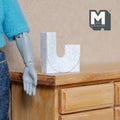 1:12 scale miniature white marble look double neck vase in a U shape, shown on a wood dresser beside a figure's hand