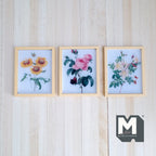 1:12 scale miniature wood framed flower prints, set of 3 botanical designs, shown hanging on a white plank wall