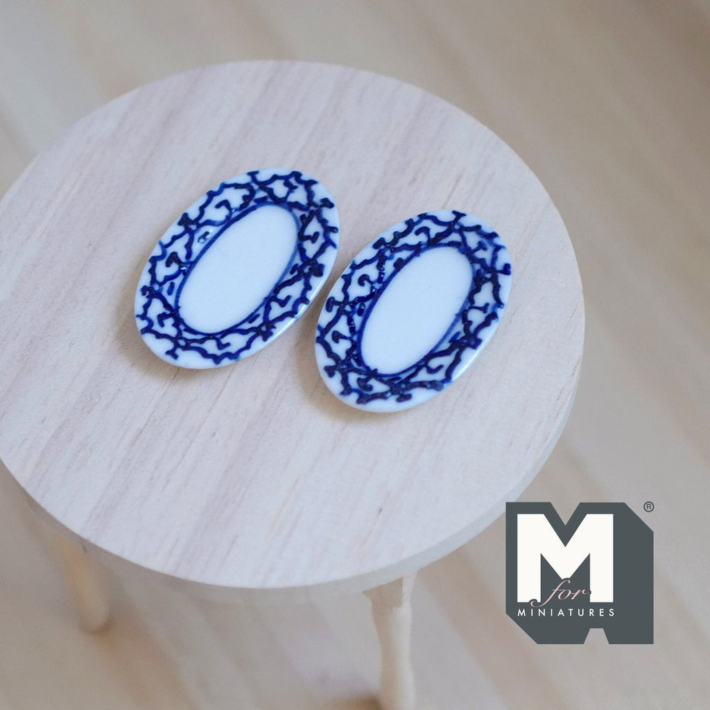 1:12 scale miniature ceramic oval plates with blue rim pattern on white, set of 2, shown on a round wood table