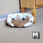 1:12 scale miniature plush fabric dog bed in cream with brown paw print pattern and tan cushion, shown on the floor