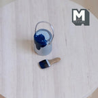 1:12 scale miniature paint can with brush, set of 2, silver can with dark blue paint, shown on a round wood table