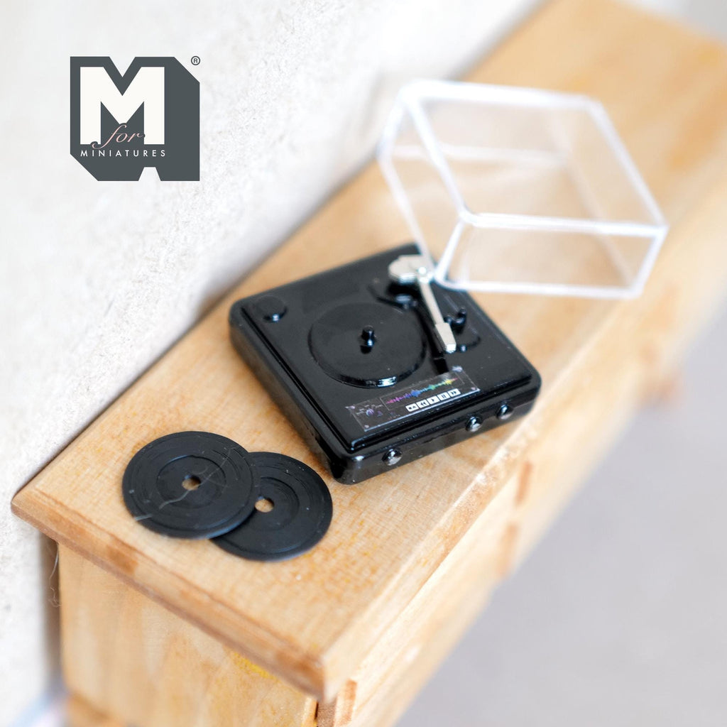 1:12 scale miniature metal turntable in black with clear dust cover and 2 vinyl records, non working, on a dresser