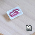 1:12 scale miniature raw steak slice on white tray, red marbled meat, non edible, shown on a light wood table