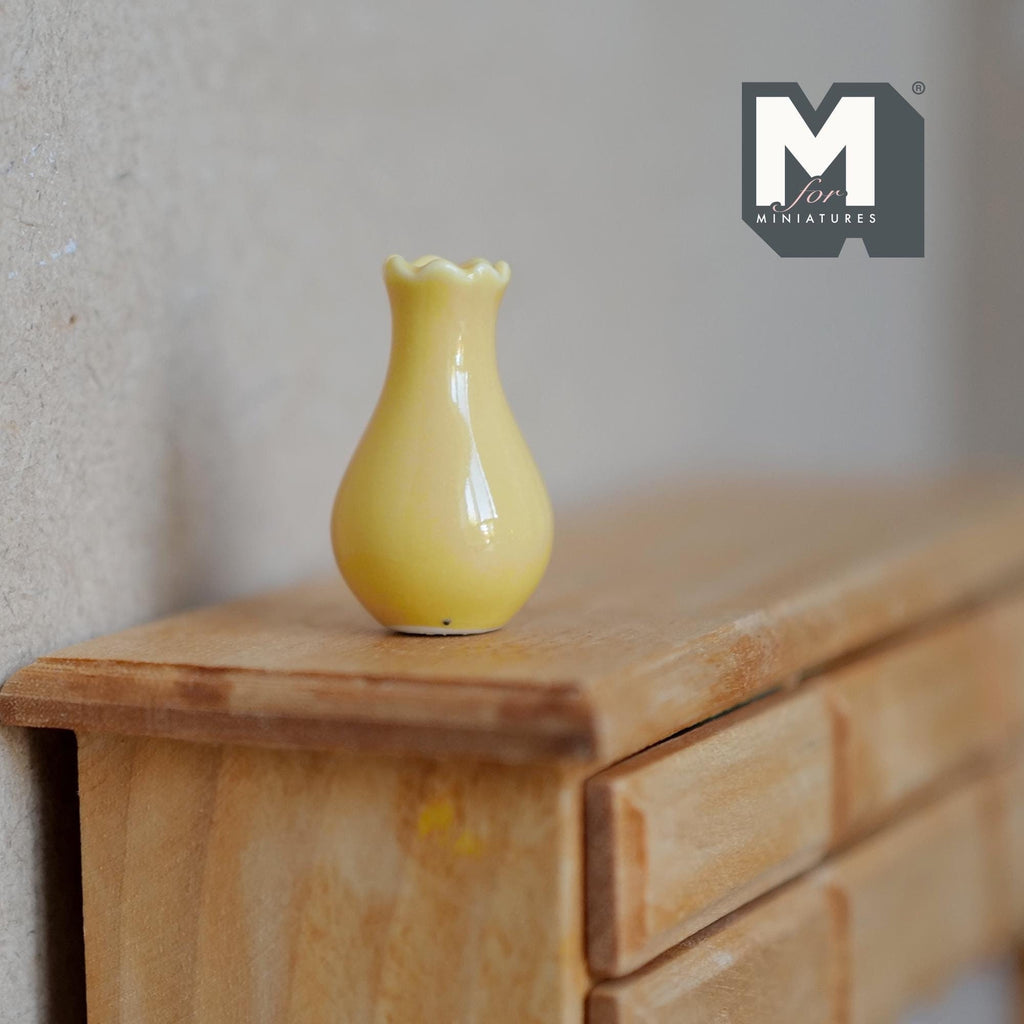 1:12 scale miniature ceramic pear shaped vase in yellow with a flared scalloped lip, shown on a wood dresser