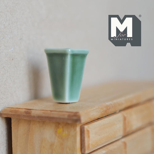 1:12 scale miniature ceramic square tapered vase in glossy jade green, shown on a wood dresser