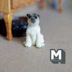1:12 scale miniature sitting pug dog figurine in beige cast resin with dark face, shown on a carpet floor