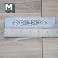 1:12 scale miniature white lace style table runner with scroll cutout pattern, shown with a ruler on a wood floor