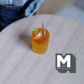 1:12 scale miniature fruit punch in a glass with ice, large, orange drink with garnish, non edible, on a wood table