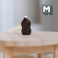1:12 scale miniature dark brown BBQ sauce bottle with white cap and contoured sides, shown on a round wood table