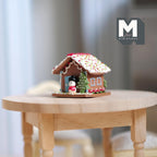 1:12 scale miniature gingerbread house with snowman, tree and gingerbread man, iced roof, shown on a round wood table