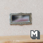 1:12 scale miniature antique silver ornate rectangular vanity mirror, shown hanging on a beige wall