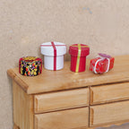 1:12 scale miniature wood Christmas wrapped gift boxes, round and square, set of 4 in red and white, on a wood dresser