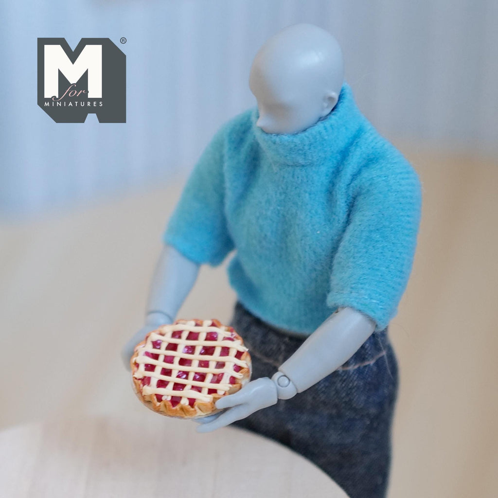 1:12 scale miniature lattice top berry pie on metal plate, red filling with golden crust, held by a jointed figure