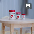 1:12 scale miniature wood kitchen jars in white and red with fixed lids and floral print, set of 3, on a table