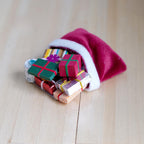 1:12 scale miniature Christmas sack of presents, red with white trim, all in 1 piece, wrapped gifts spilling out on wood