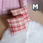 1:12 scale miniature fabric square cushions in red plaid, set of 2, shown on a fluffy white rug