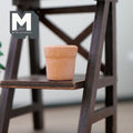 1:12 scale miniature clay flower pot in terracotta, round tapered shape, shown on a dark wood plant stand