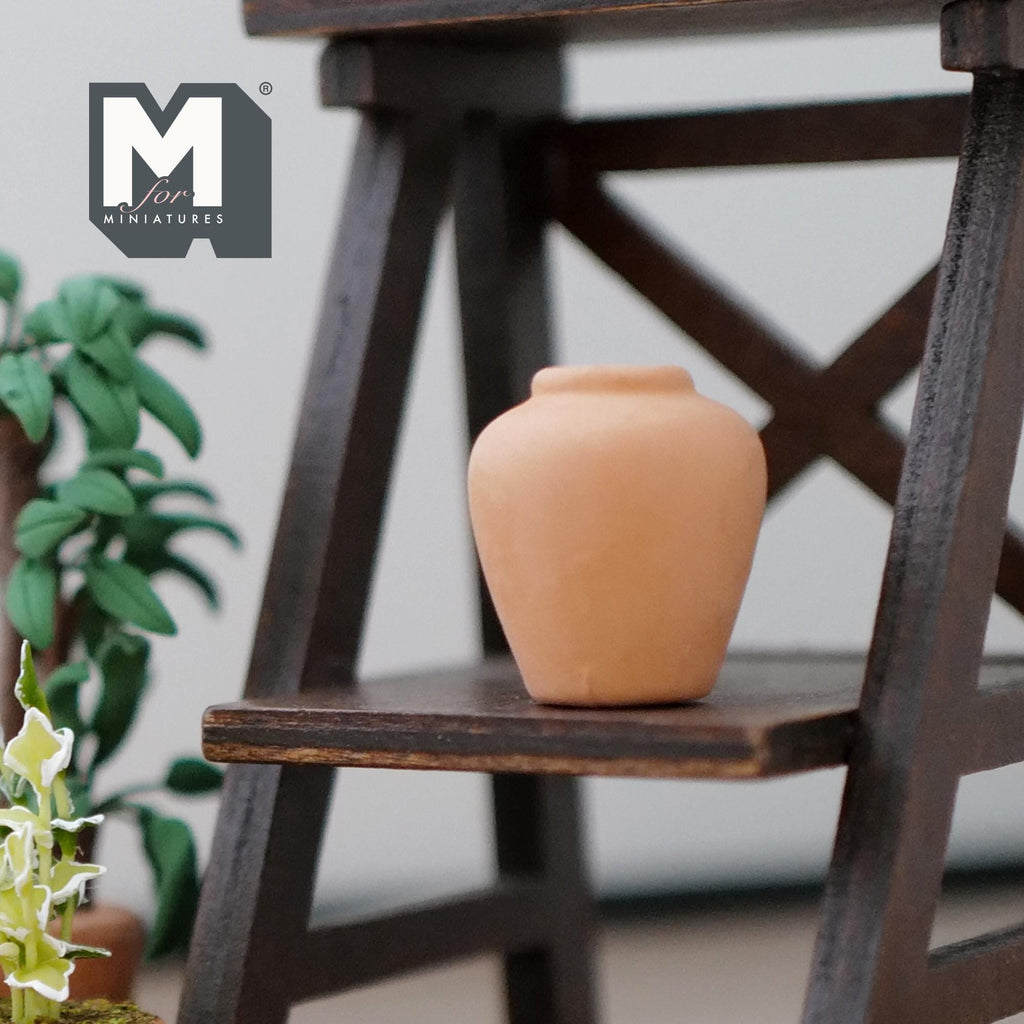 1:12 scale miniature clay plum shaped vase in plain terracotta, shown on a dark wood shelf beside green plants