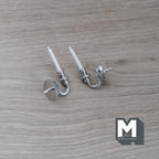 1:12 scale miniature metal wall candle sconces in silver with white candles, set of 2, lying on a wood surface