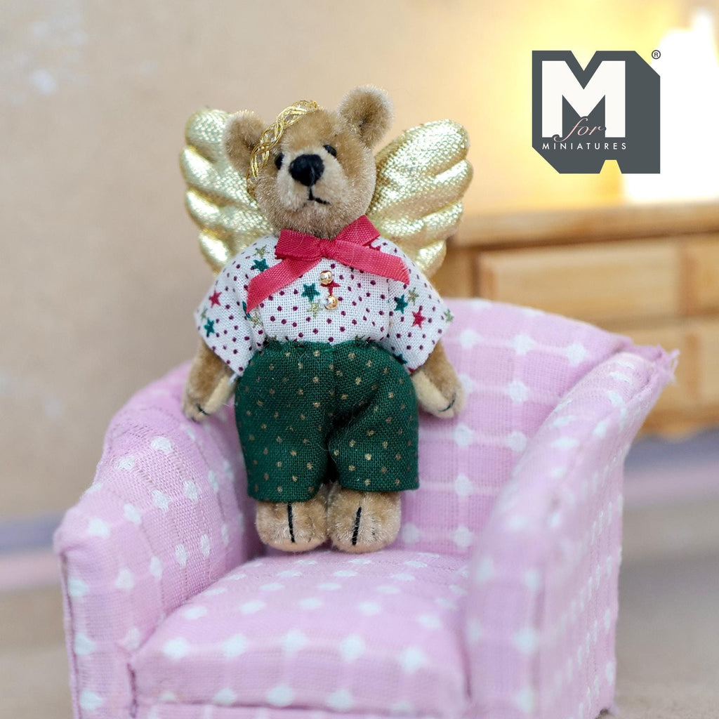 1:12 scale miniature plush bear with golden angel wings and movable limbs, star print shirt and green pants, on a pink chair