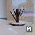 1:12 scale miniature wood cat tree with dark brown scratching posts, hanging ball toys and a round cream base