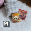 1:12 scale miniature children's story books with illustrated covers, set of 2, shown on a white fur rug by a pillow