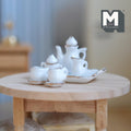 1:12 scale miniature ceramic tea set in white with gold trim, set of 8 with teapot, cups and tray, on a round table