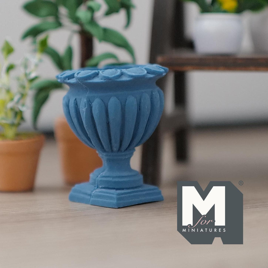 1:12 scale miniature cast resin Roman style pedestal urn vase in blue with fluted sides, shown on a floor near potted plants