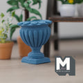 1:12 scale miniature cast resin Roman style pedestal urn vase in blue with fluted sides, shown on a floor near potted plants