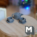 1:12 scale miniature metal pentagon teapot with cups and plates in gray, set of 5, shown on a round wood table