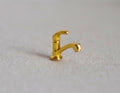 1:12 scale miniature single lever faucet in gold with a gooseneck spout, shown standing on a beige surface