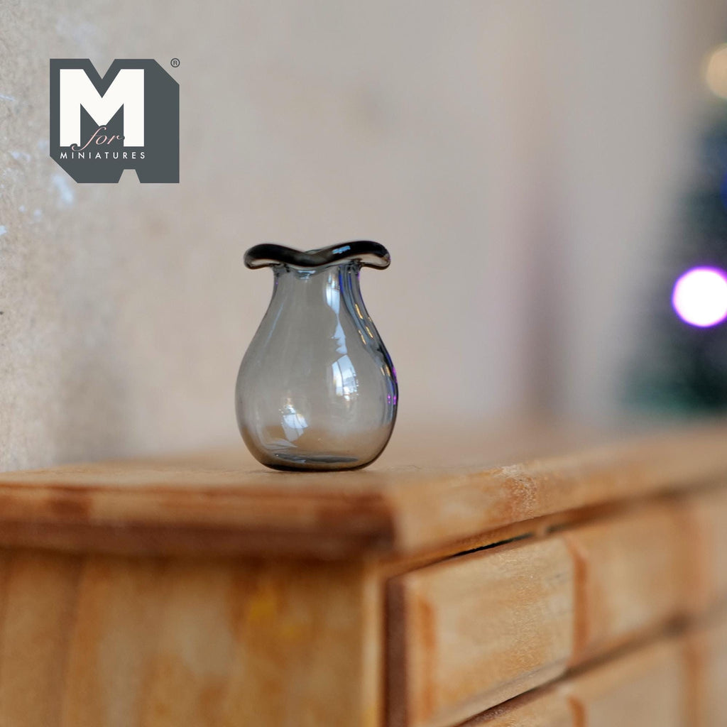 1:12 scale miniature glass pear shaped vase in gray with a dark ruffled rim, shown on a wood dresser
