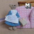 1:12 scale miniature plush lady bear with a basket of eggs, blue gingham dress and white apron, shown by a pink armchair