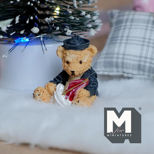 1:12 scale miniature resin bear cub figurine in navy sailor outfit holding a sail boat, on a white fur rug