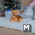 1:12 scale miniature resin bear figurine playing violin, seated brown bear on white fur beside a Christmas tree