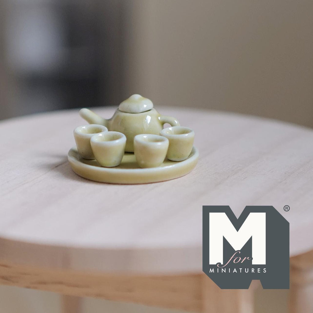 1:12 scale miniature ceramic tea set with tray in pale yellow, set of 6 with teapot and cups, on a round wood table