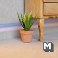 1:12 scale miniature potted succulent in a terracotta pot with spiky yellow edged leaves, shown beside a wood dresser leg