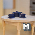 1:12 scale miniature metal pentagon teapot with cups and plates in dark blue, set of 5, on a round wood table