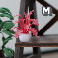 1:12 scale miniature potted spiky leaf plant in red with a white pot, shown on a dark wood plant stand